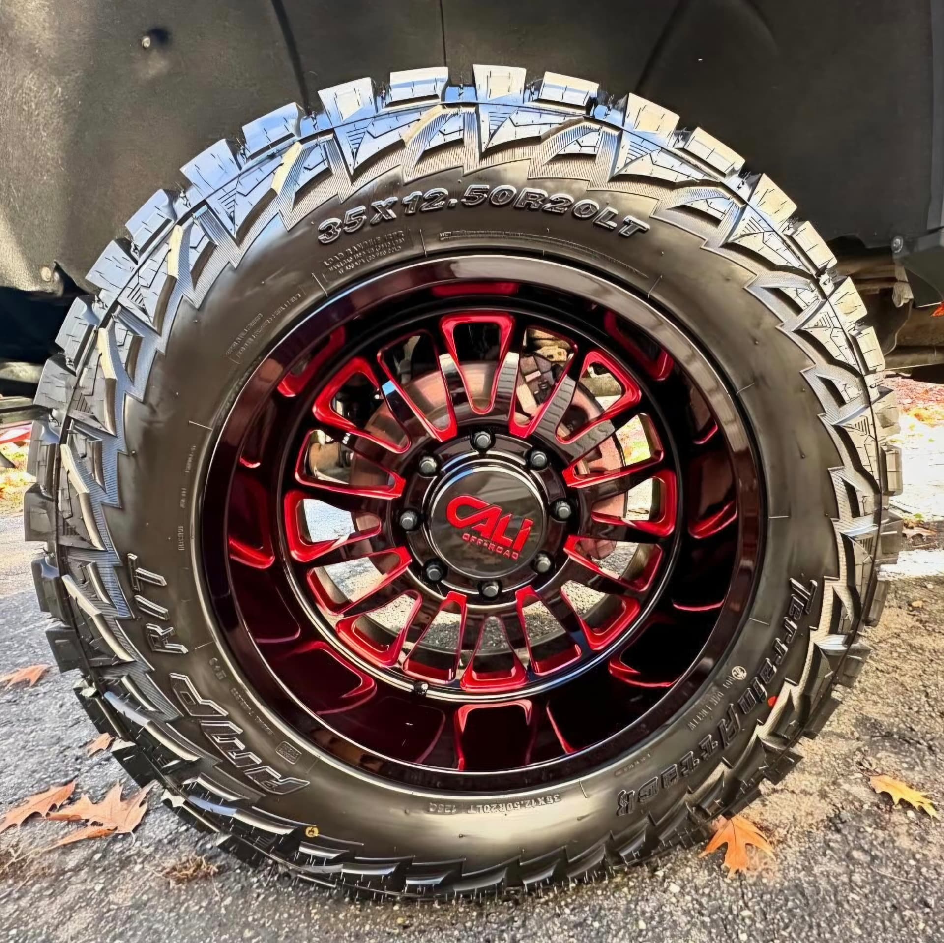 Red and black Cali off-road wheel with a freshly dressed tire